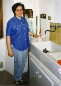 Claudia con un gatto che sta bevendo acqua dal rubinetto